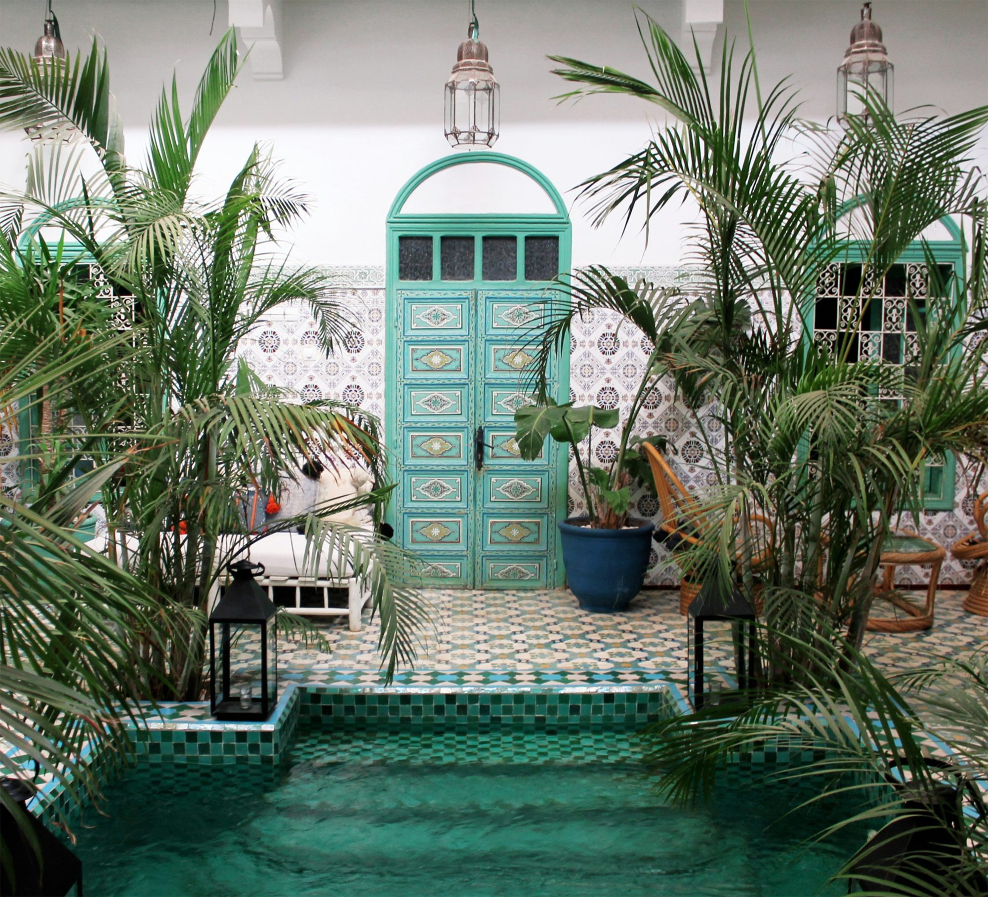 Zellige-tiled plunge pool and palms in a riad courtyard